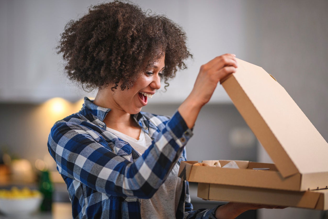 Excited Young Mixed Race Woman Looking at Delivery Pizza