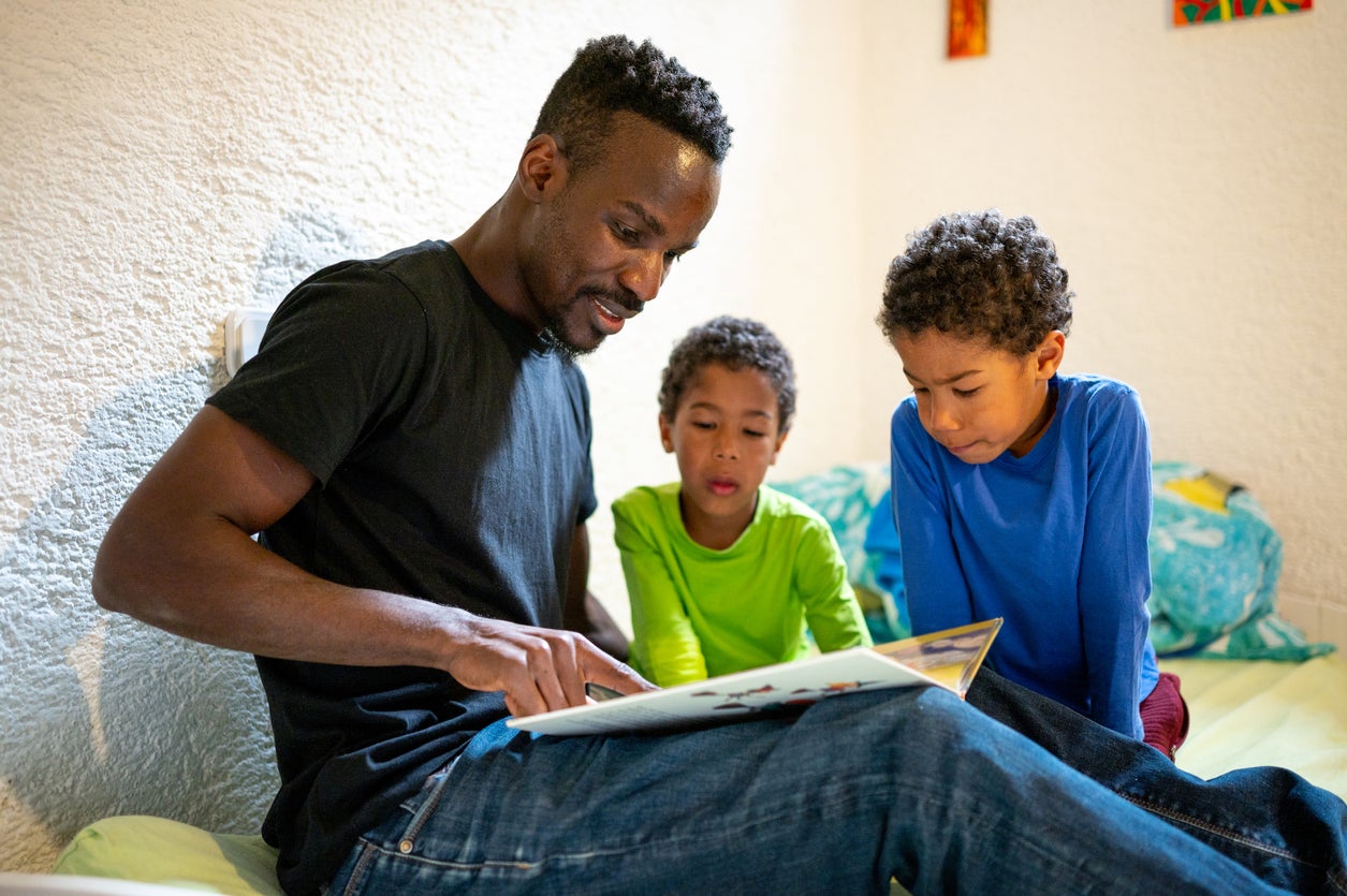 Father reading a story to his two sons