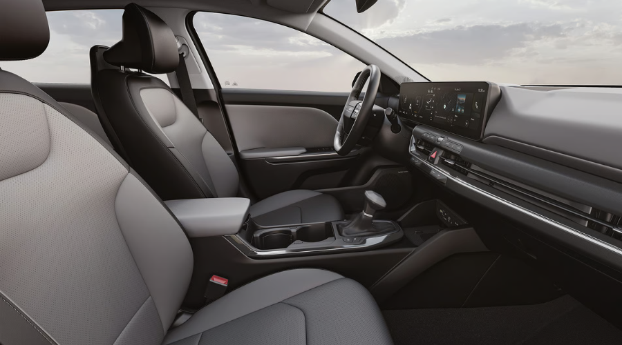 Modern front cabin and dashboard of the 2026 Kia K4 compact sedan highlighting comfortable two-tone seats, center console layout, and digital infotainment system, in stock at Classic Kia near Lake County
