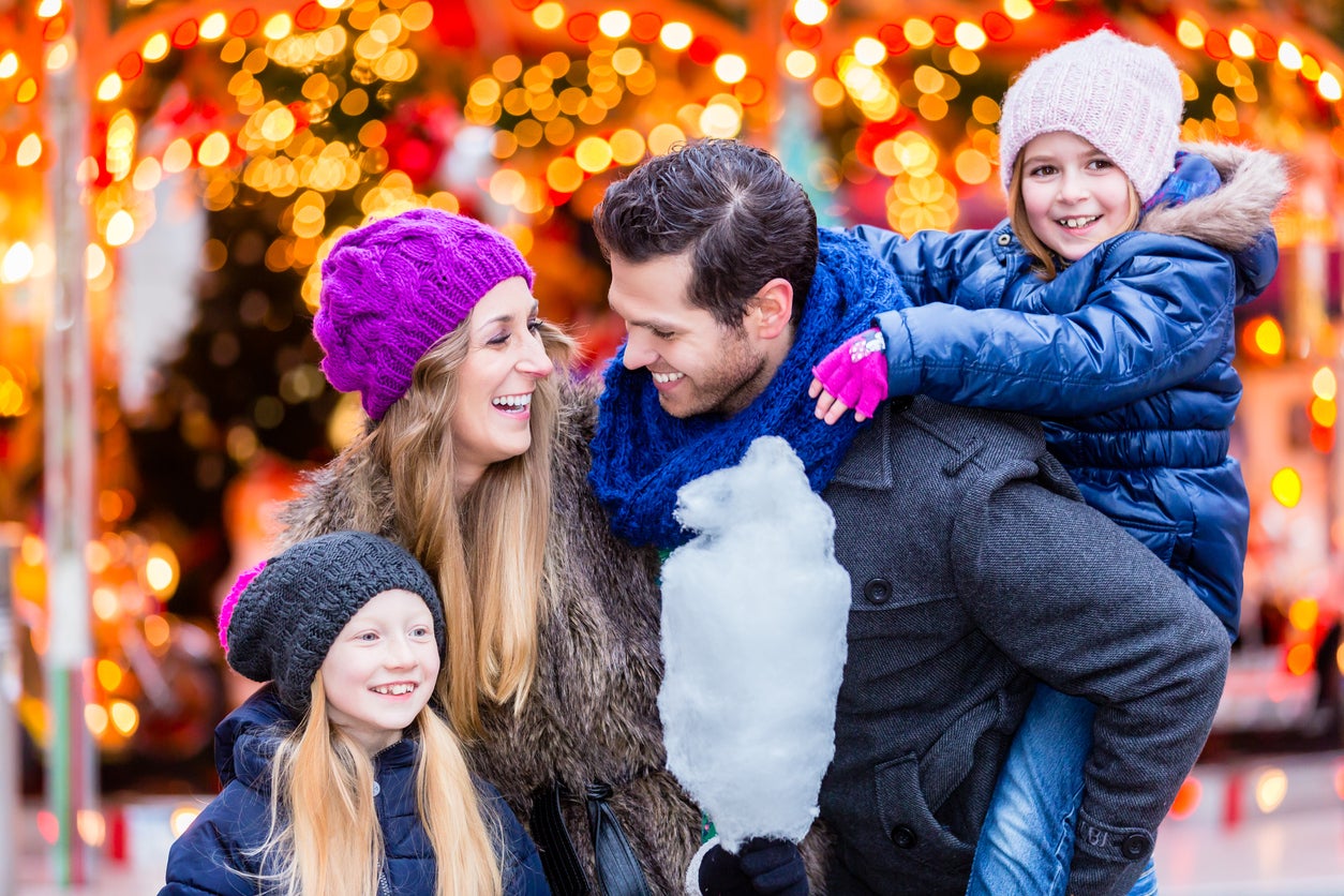 Family eating cotton candy on Christmas market