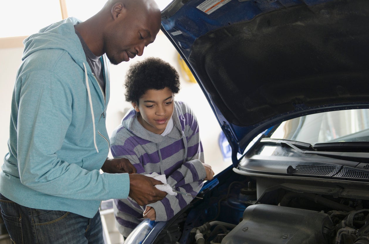 father teaching son about car repair