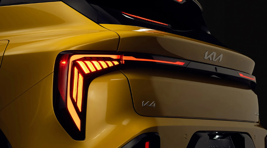 The athletic rear profile and modern LED taillight design of the new 2026 Kia K4 Hatchback in Sparkling Yellow on display at Classic Kia in Waukegan, IL
