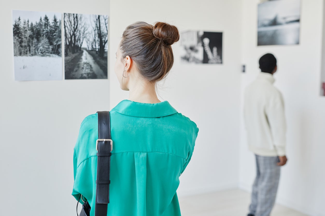 People Looking at Art in Gallery Back View