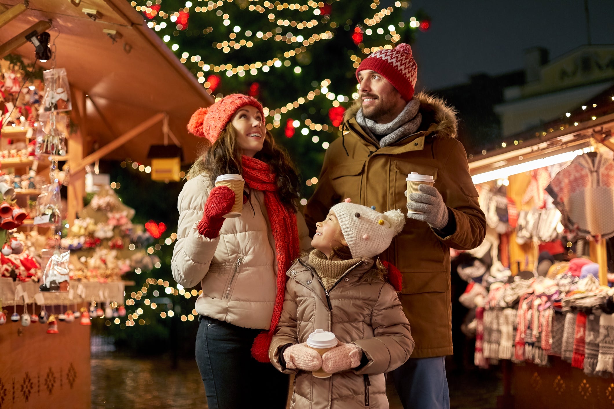family with takeaway drinks at christmas market