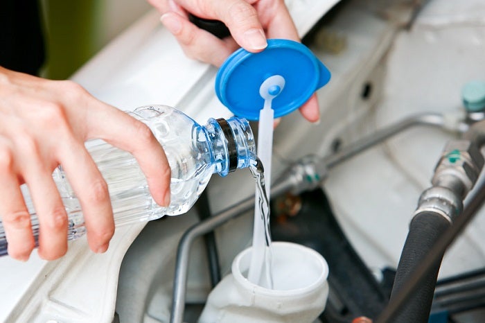 Fill the windshiend water liquid on a car.