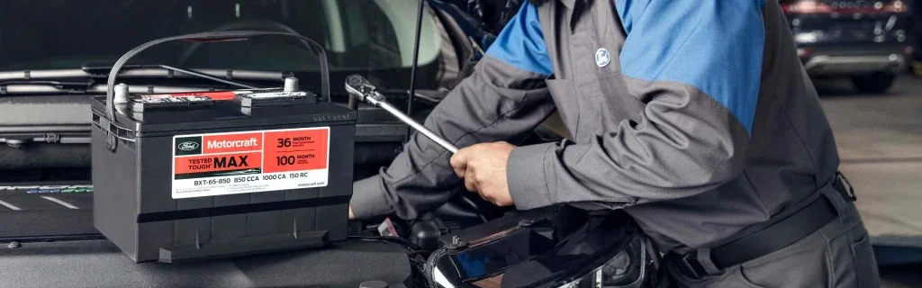 Technician installing a Motorcraft battery during Ford vehicle service.