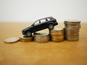 A toy model car sloped downwards on stacked coins.
