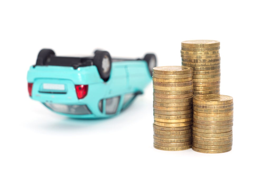 Coins,Stack,With,A,Blue,Overturned,Model,Car,And,Financial