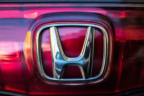 Close on Honda logo on red 2021 Honda Civic Sedan body