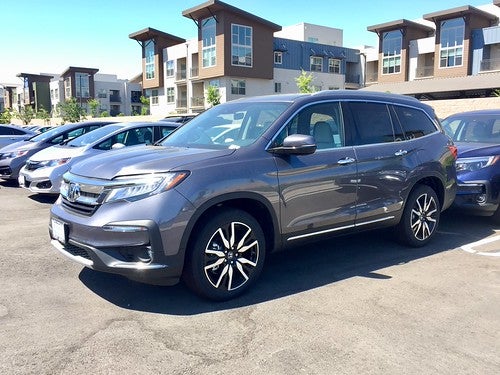 Grey Honda Pilot parked in a residential parking lot