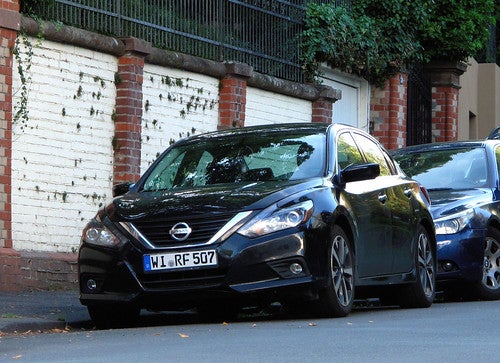 Dark blue Nissan Altima parked on European street
