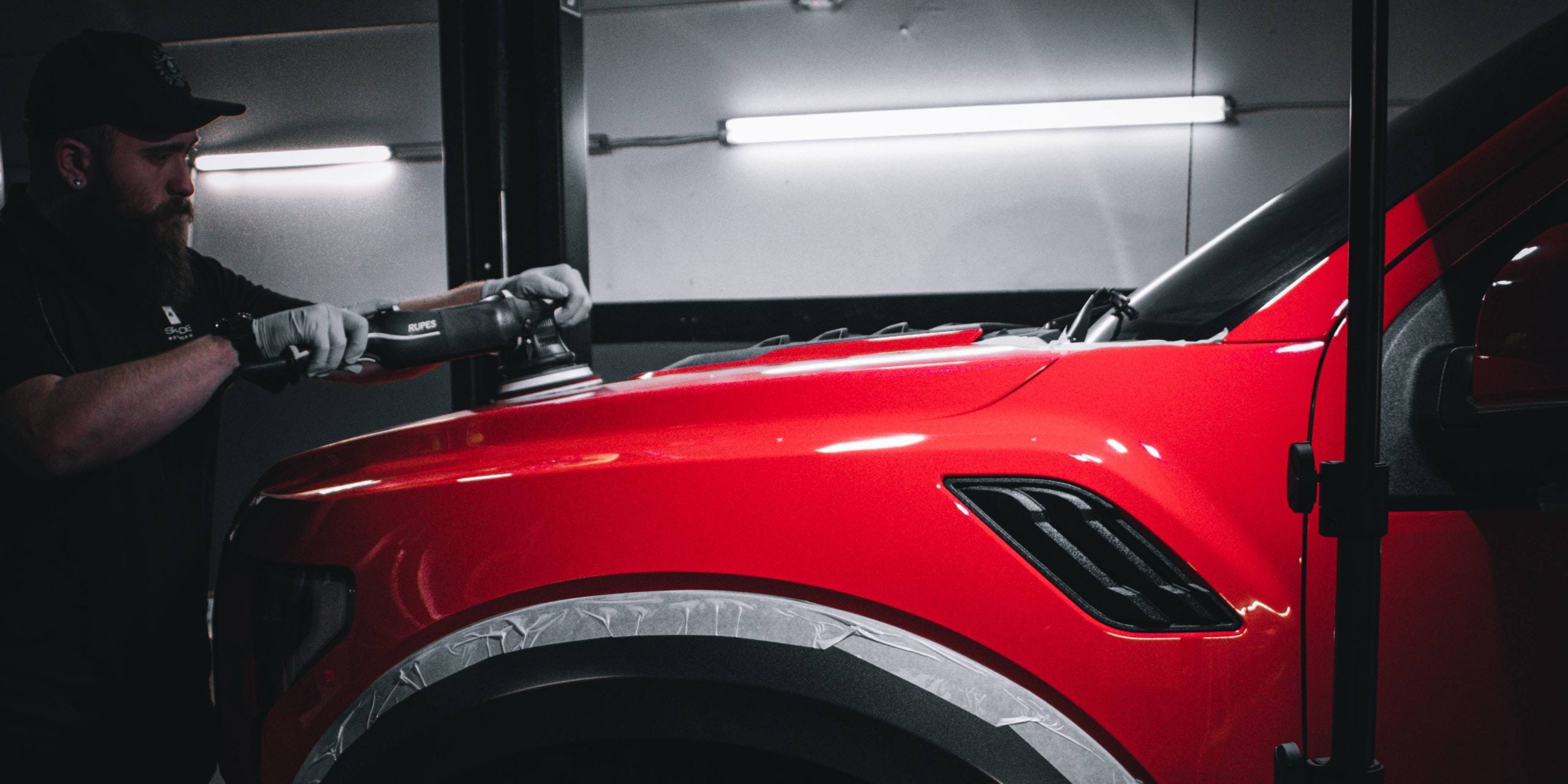 Auto detailing expert finishing detailing on red truck