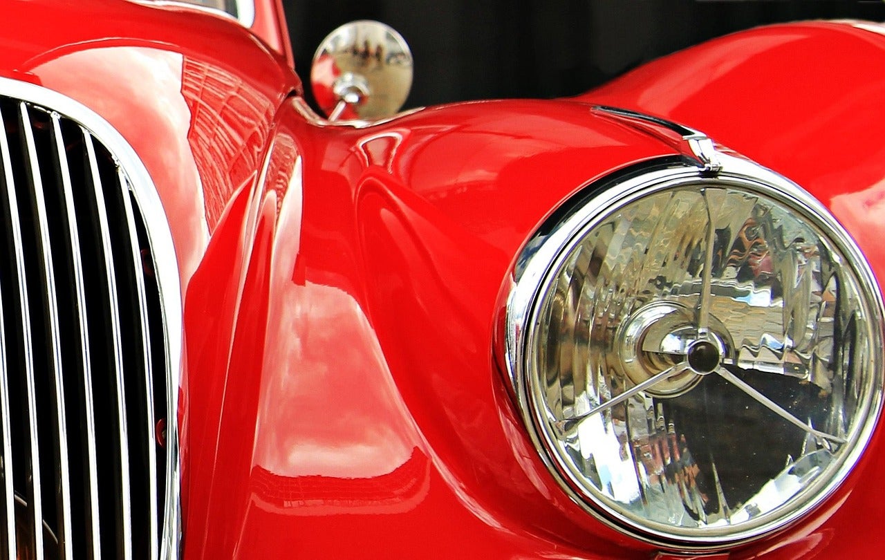 Close on headlight of classic red car