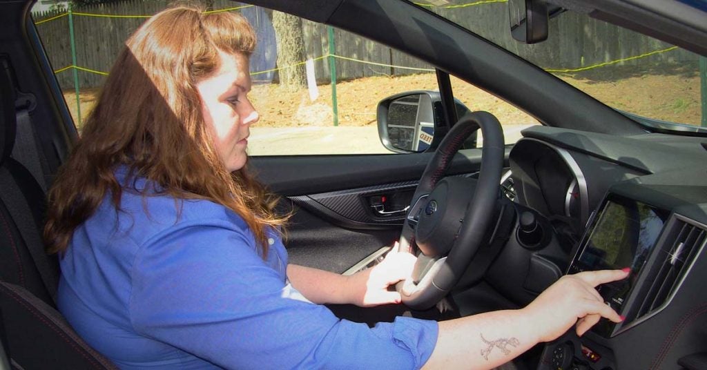 Amber picks a song with the apps on the Subaru Impreza Sport
