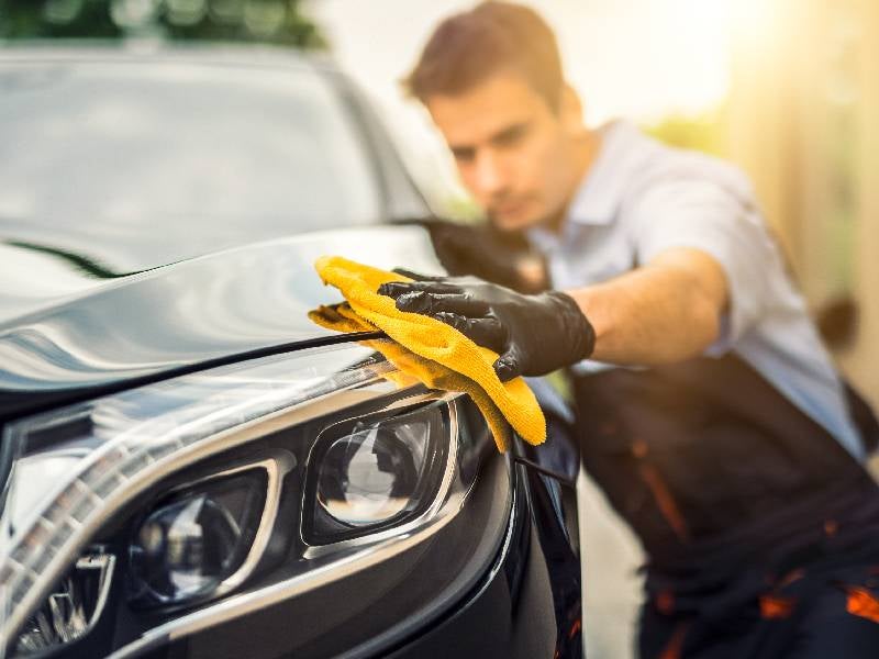 man wiping a clean car