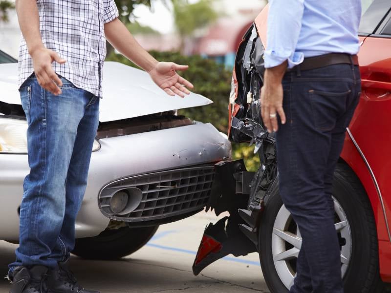 two menu arguing over the damage on their cars after a collision
