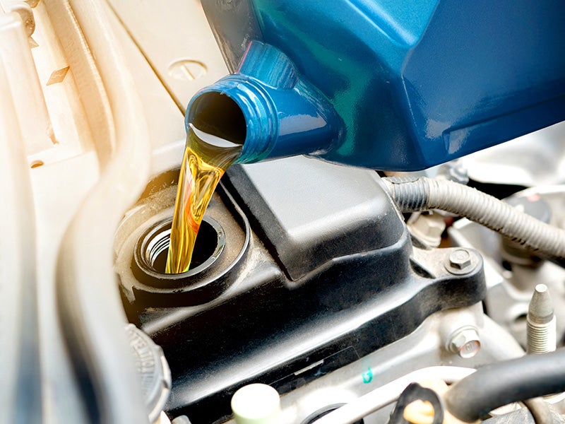 close up of oil pouring into an engine