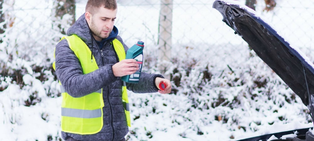 A technician performing an oil change during the winter
