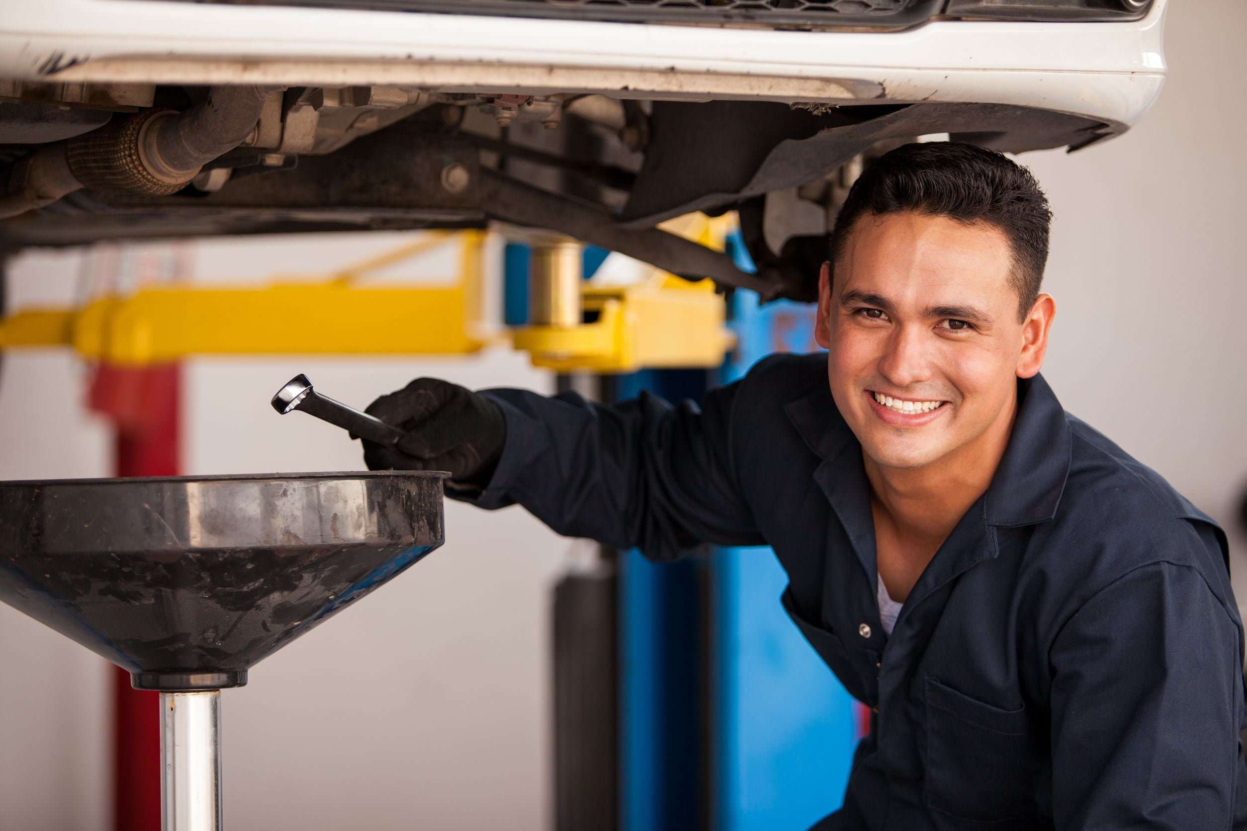 smiling man performing oil change