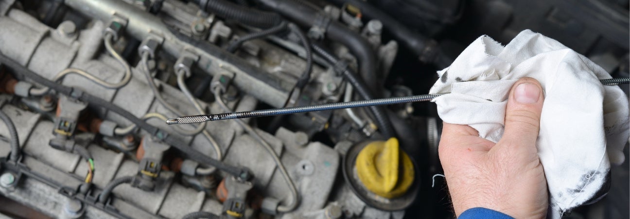 Service technician wiping dipstick