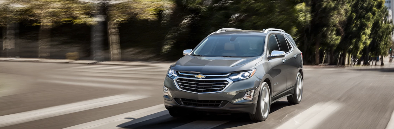 A gray 2018 Chevy Equinox driving down the street.
