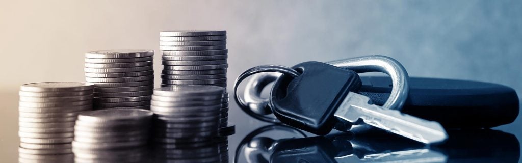 Stacks of coins next to a car key.
