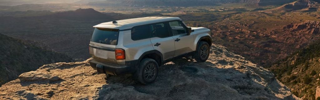 Silver Toyota Land Cruiser on a desert cliff.
