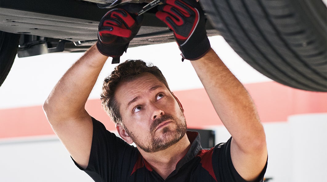 Bennett Toyota of Allentown is a Car Dealership near Westwood Heights PA in Allentown | Toyota Service Advisor Doing Repairs on Undercarriage of Toyota Vehicle