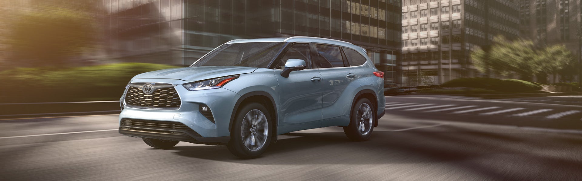 Model Features of the 2021 Toyota Highlander at Bennett Toyota | Blue 2021 Toyota Highlander Driving Through City