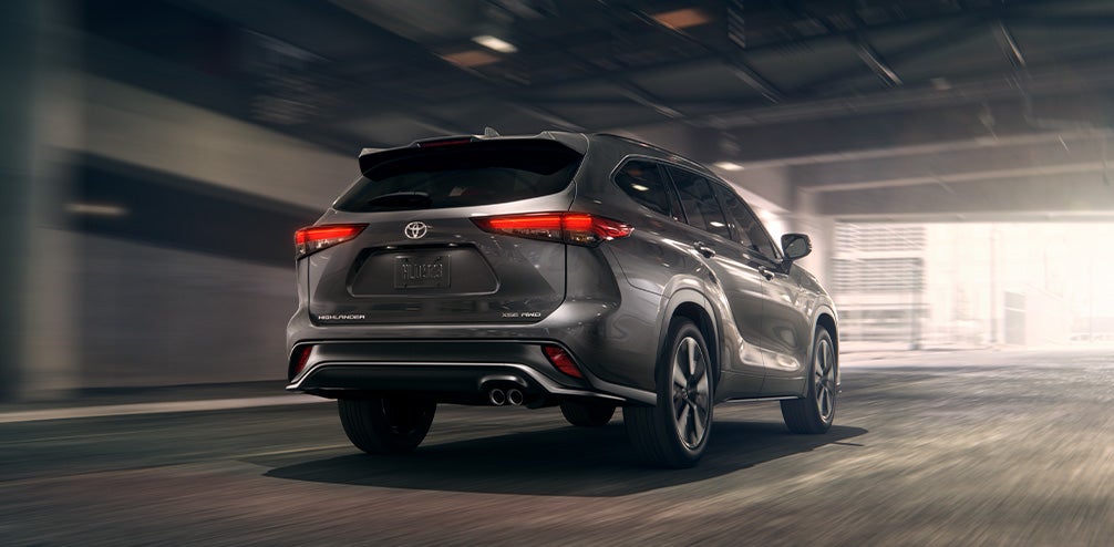 Model Features of the 2021 Toyota Highlander at Bennett Toyota | Rearview of Dark Silver 2021 Toyota Highlander Driving Under City Underpass