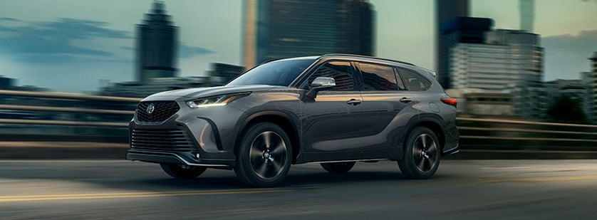 The 2022 Toyota Highlander vs. The 2021 Toyota Highlander at Bennett Toyota | Silver 2021 Toyota Highlander Driving Fast Away from City