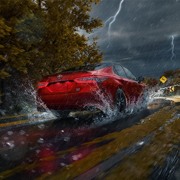 The 2021 Toyota Camry vs. The 2021 Honda Accord at Bennett Toyota | Red 2021 Toyota Camry Driving in Downpour with Lightning in the Distance