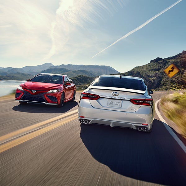 The 2021 Toyota Camry vs. The 2021 Honda Accord at Bennett Toyota | Red and White 2021 Toyota Camry Vehicles Driving Past Eachother on Road