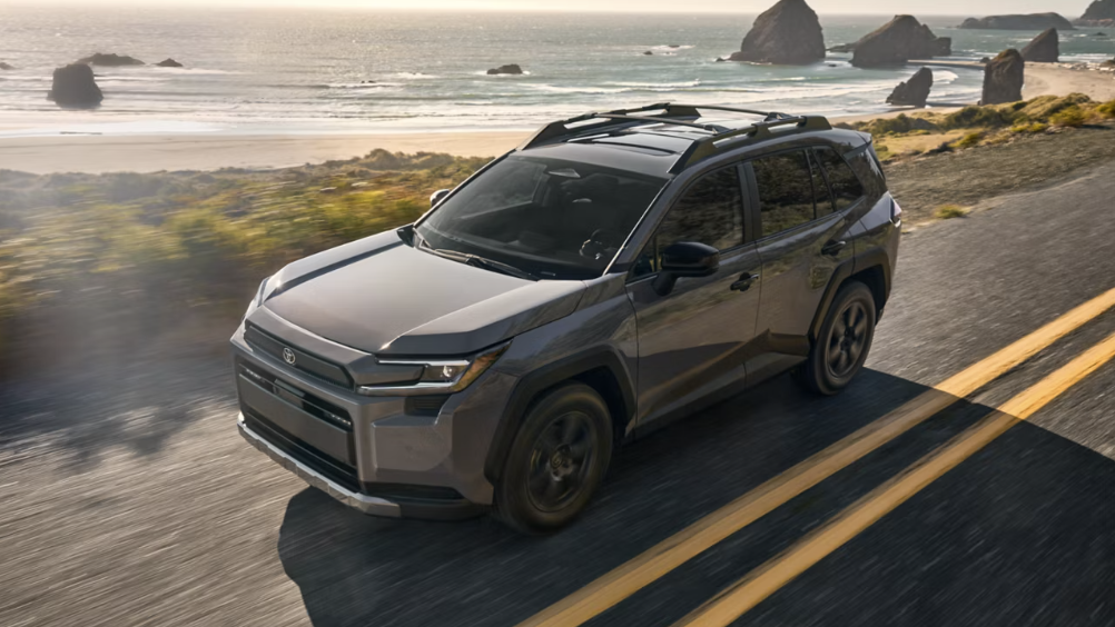 2026 Toyota RAV4 Hybrid driving along a scenic coastal highway near the ocean