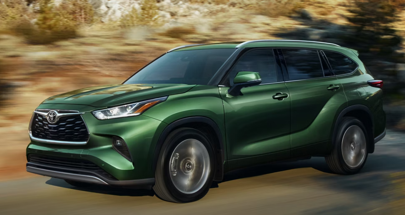 Green Highlander driving through desert