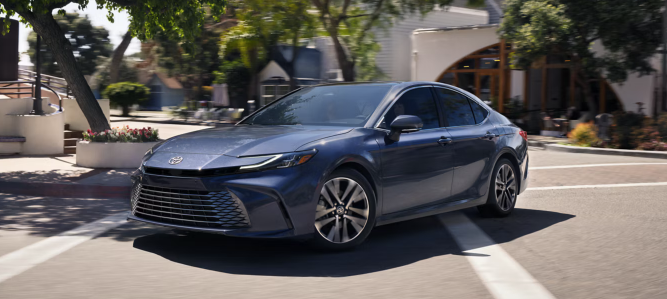 2026 Toyota Camry driving through a tree-lined neighborhood
